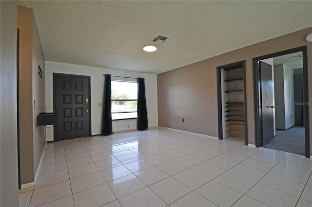 tiled entrance foyer featuring a textured ceiling