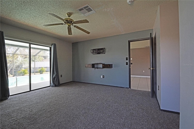 empty room with ceiling fan, carpet floors, and a textured ceiling