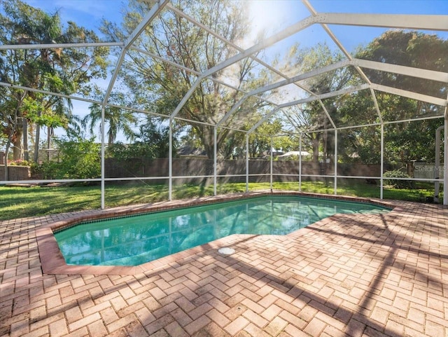 view of pool with a lanai, a patio area, and a yard