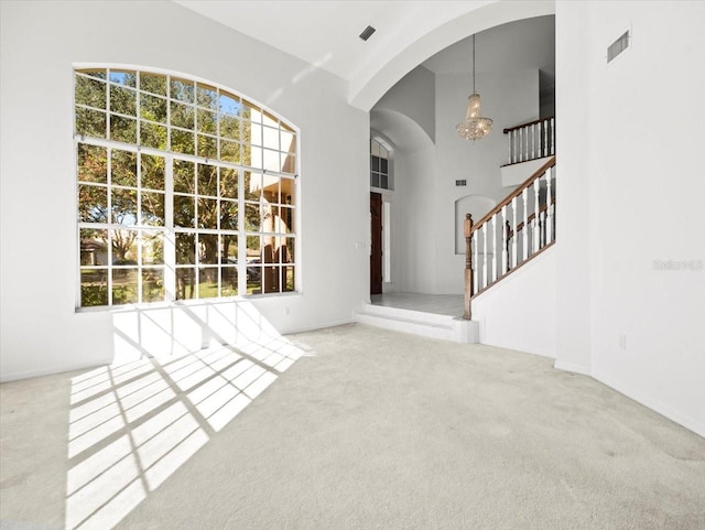 entrance foyer with carpet and high vaulted ceiling