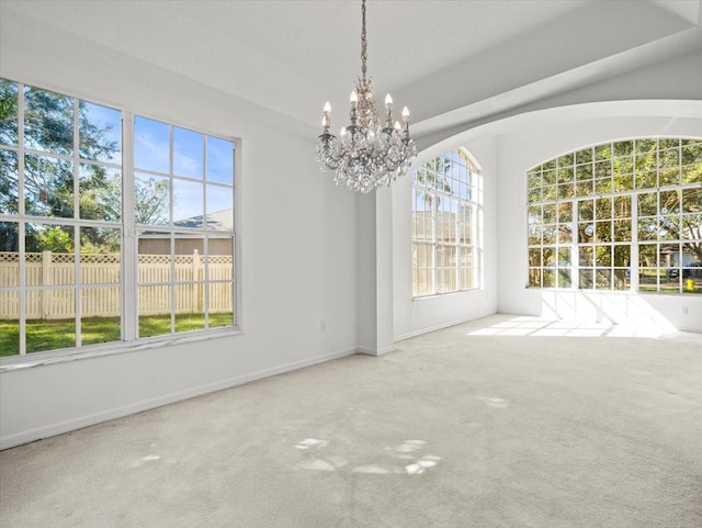 unfurnished dining area featuring carpet flooring and an inviting chandelier