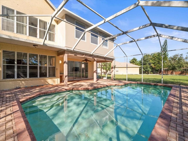 view of swimming pool with a patio, glass enclosure, and ceiling fan