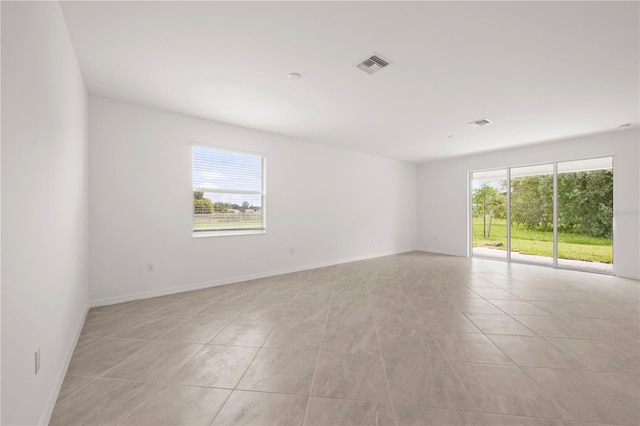 tiled spare room with plenty of natural light