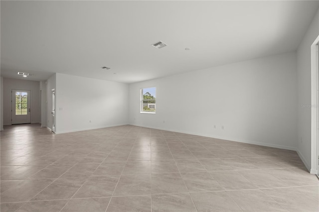 empty room with a healthy amount of sunlight and light tile patterned flooring