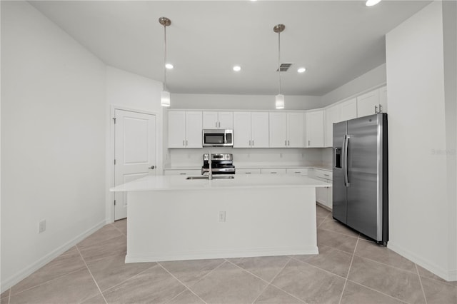 kitchen with white cabinets, a kitchen island with sink, hanging light fixtures, and appliances with stainless steel finishes