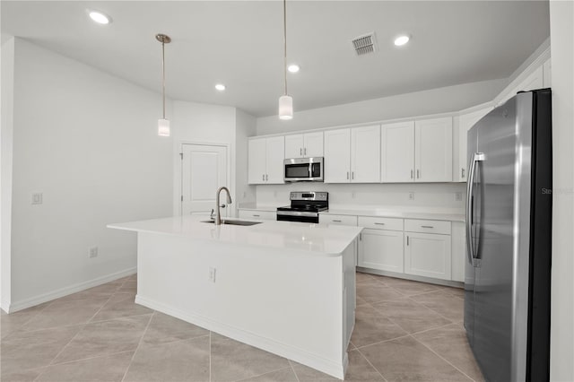 kitchen with sink, hanging light fixtures, stainless steel appliances, a center island with sink, and white cabinets