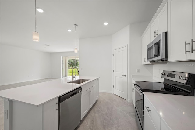 kitchen featuring pendant lighting, sink, an island with sink, appliances with stainless steel finishes, and white cabinetry