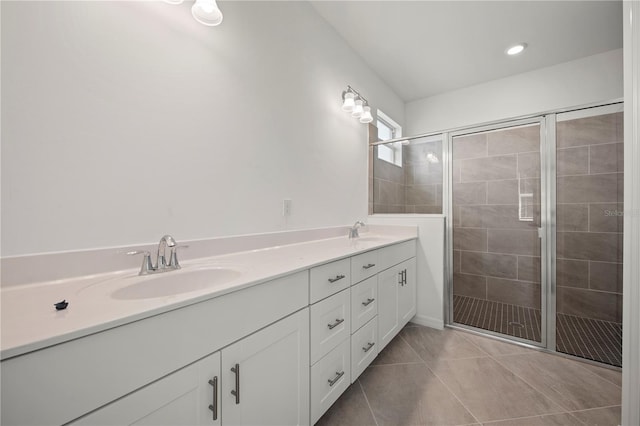 bathroom with tile patterned flooring, vanity, and walk in shower