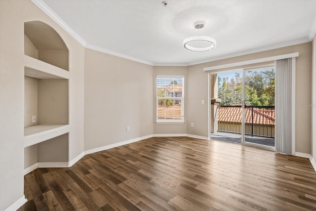 empty room with dark hardwood / wood-style floors, built in features, and ornamental molding