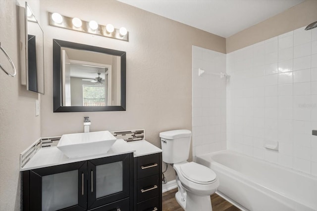 full bathroom featuring vanity, tiled shower / bath combo, ceiling fan, wood-type flooring, and toilet