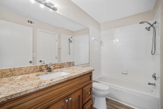 full bathroom featuring toilet, vanity, tiled shower / bath combo, and hardwood / wood-style flooring