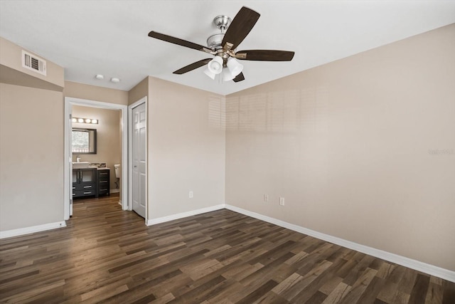 spare room featuring ceiling fan and dark wood-type flooring