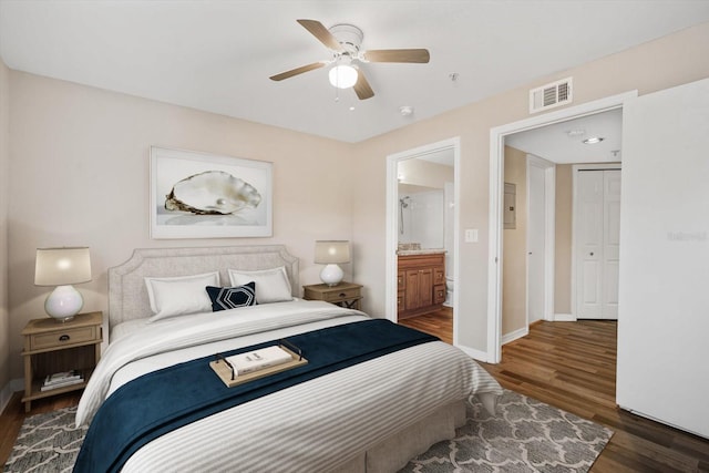 bedroom featuring dark hardwood / wood-style flooring, ensuite bath, and ceiling fan