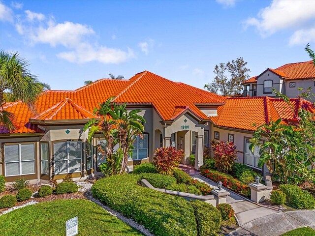 18106 Peregrines Perch Pl Unit 5204, Lutz, FL 33558 - mediterranean / spanish house featuring a tiled roof, stucco siding, and a front lawn