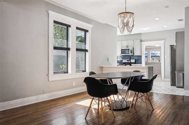 dining space featuring wood-type flooring and a chandelier