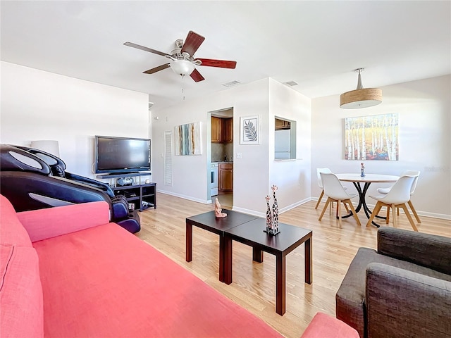 living room with light hardwood / wood-style flooring and ceiling fan