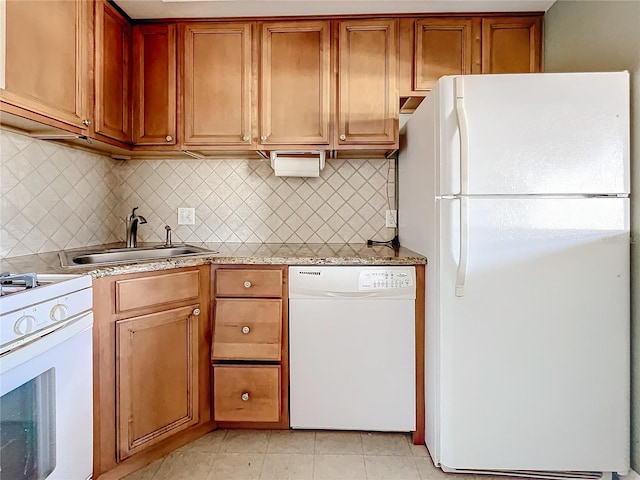 kitchen with white appliances, sink, light tile patterned floors, and tasteful backsplash