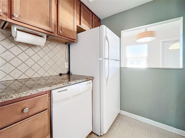 kitchen featuring dishwasher, light stone countertops, light tile patterned floors, and tasteful backsplash