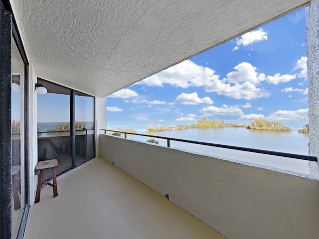 balcony featuring a water view and a sunroom