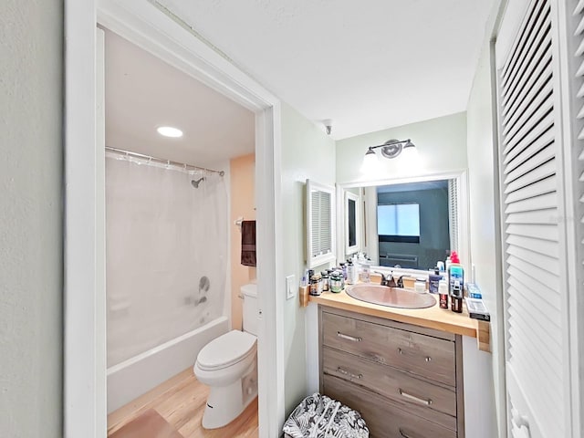 bathroom featuring a closet, toilet, shower / bath combo with shower curtain, vanity, and wood finished floors