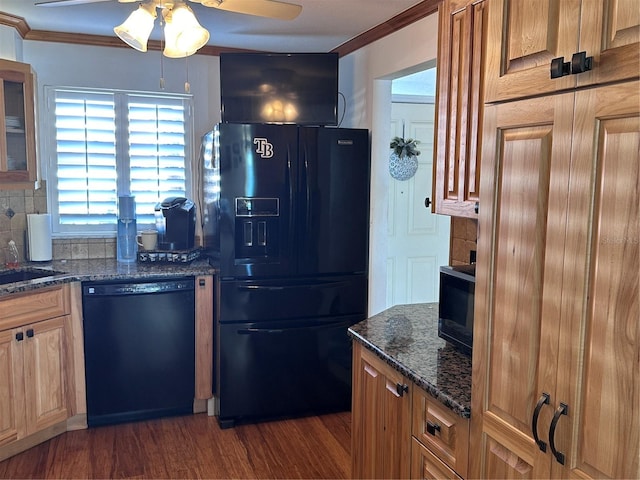 kitchen with decorative backsplash, dark hardwood / wood-style flooring, dark stone countertops, and black appliances