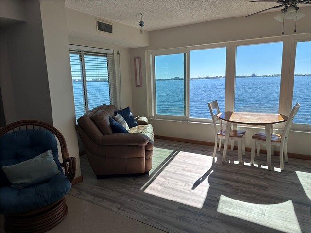 interior space with ceiling fan and a water view