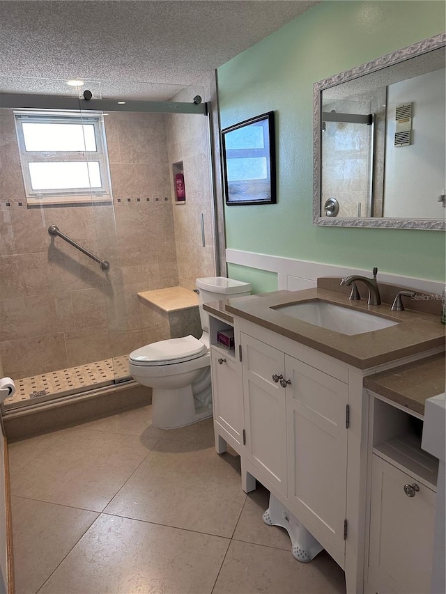 bathroom featuring tile patterned flooring, vanity, tiled shower, and a textured ceiling