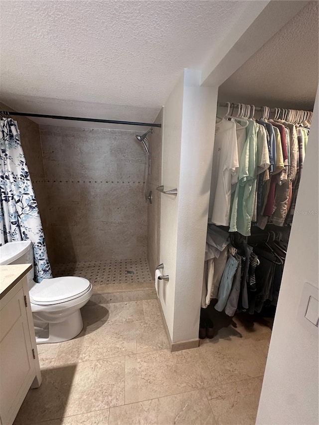 bathroom featuring a shower with shower curtain, vanity, toilet, and a textured ceiling