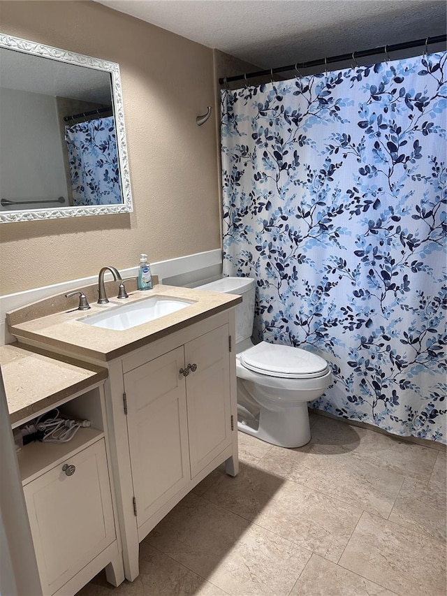 bathroom featuring vanity, toilet, and a textured ceiling