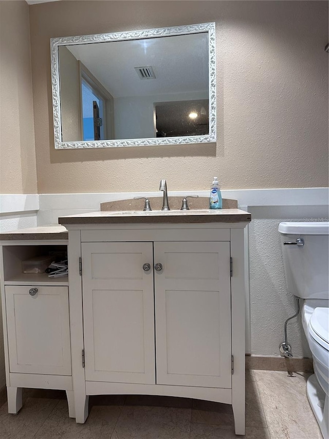 bathroom featuring tile patterned flooring, vanity, and toilet