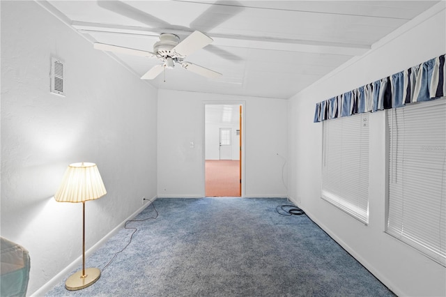 carpeted empty room featuring ceiling fan and beamed ceiling