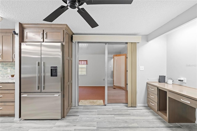 kitchen featuring stainless steel refrigerator with ice dispenser, tasteful backsplash, a textured ceiling, ceiling fan, and light hardwood / wood-style floors