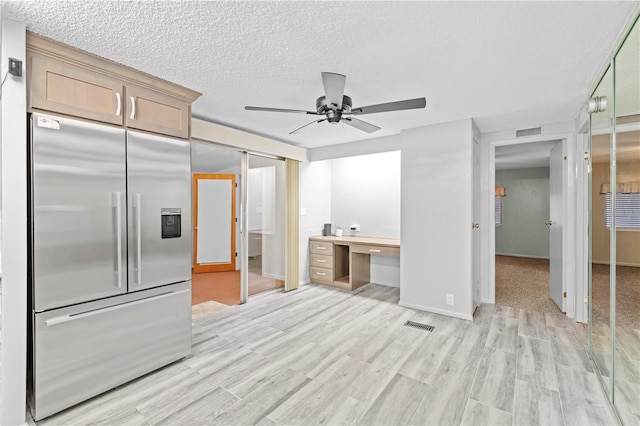 kitchen with light brown cabinetry, light wood-type flooring, high end fridge, a textured ceiling, and ceiling fan