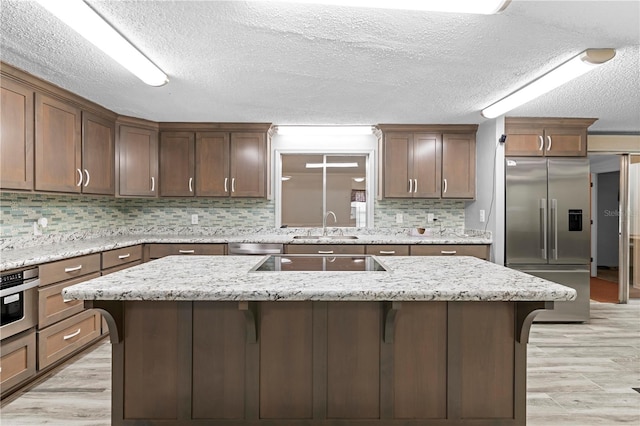 kitchen featuring a breakfast bar, light hardwood / wood-style floors, sink, and appliances with stainless steel finishes