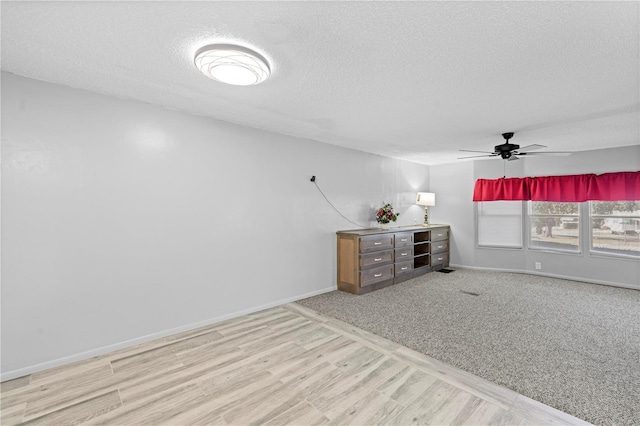 unfurnished room featuring ceiling fan, light hardwood / wood-style floors, and a textured ceiling