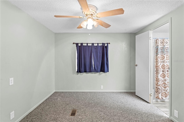 carpeted spare room featuring ceiling fan and a textured ceiling