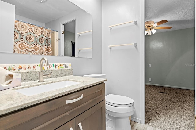 bathroom with ceiling fan, a textured ceiling, toilet, vanity, and hardwood / wood-style flooring