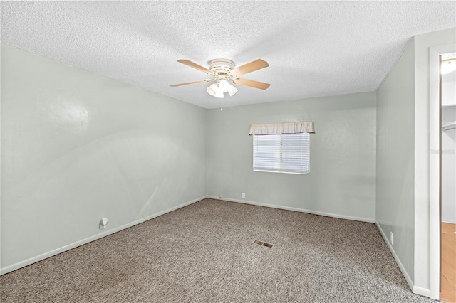 carpeted spare room featuring ceiling fan and a textured ceiling