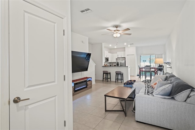 living room with ceiling fan and light tile patterned flooring