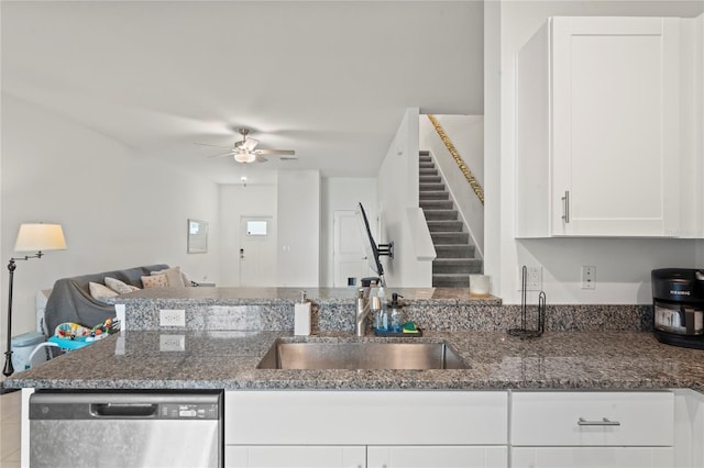 kitchen featuring dishwasher, dark stone counters, sink, ceiling fan, and white cabinetry