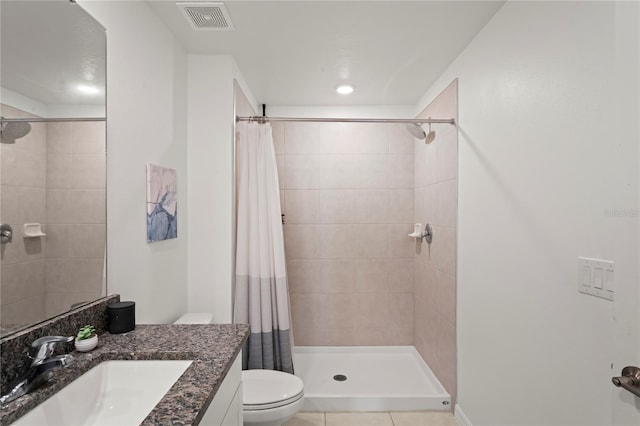 bathroom featuring tile patterned flooring, vanity, toilet, and curtained shower