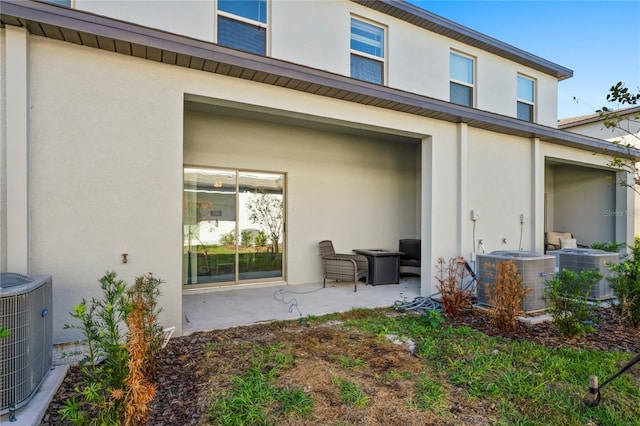 rear view of property featuring a patio and central AC