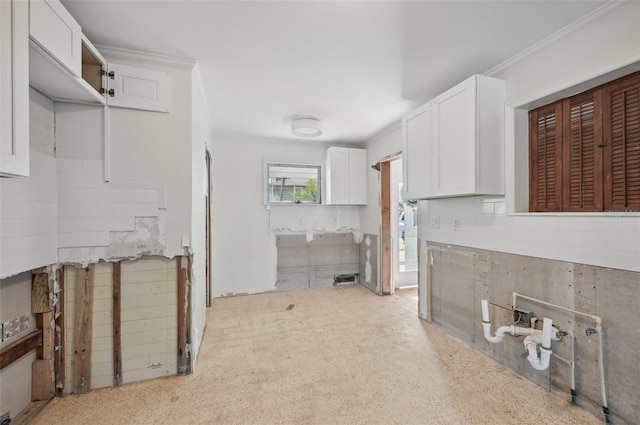 kitchen featuring white cabinets, light colored carpet, and ornamental molding