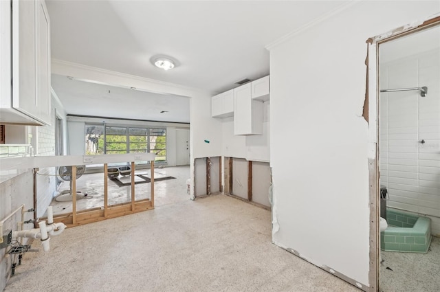 kitchen with white cabinets, crown molding, and light carpet