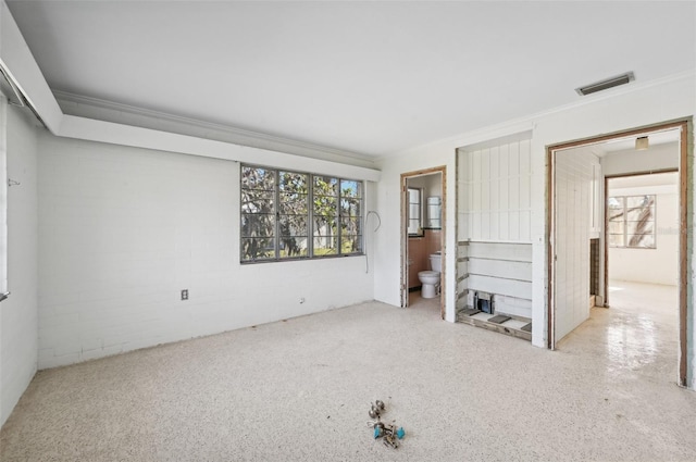 unfurnished bedroom with ensuite bathroom and ornamental molding