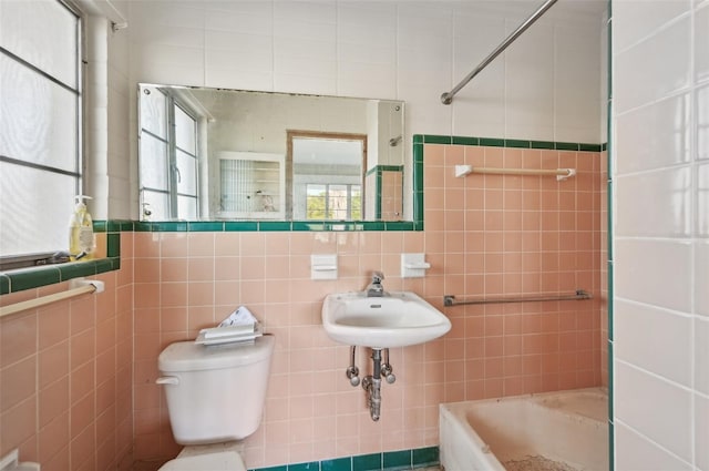 bathroom with toilet, tile walls, and sink