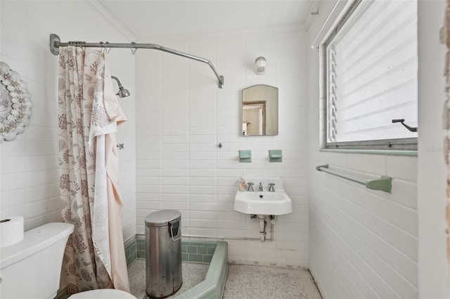 bathroom featuring a shower with shower curtain, toilet, tile walls, and sink