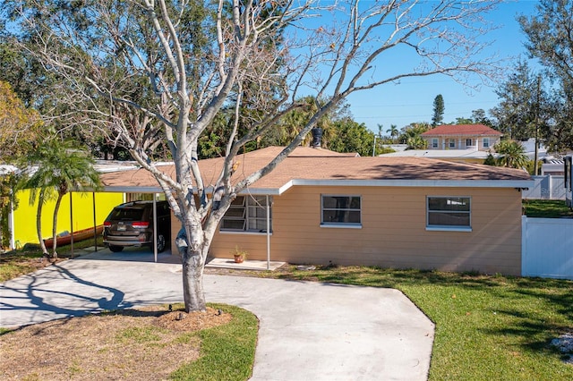 view of front facade with a carport and a front lawn