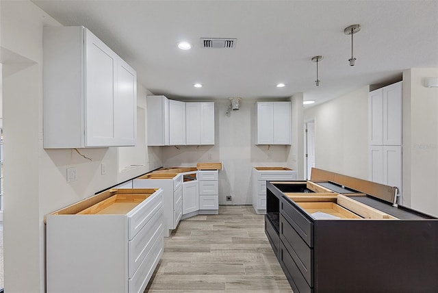 4145 Harrisburg St NE, Saint Petersburg, FL 33703 - kitchen featuring recessed lighting, white cabinets, and light wood-style flooring