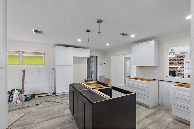 4145 Harrisburg St NE, Saint Petersburg, FL 33703 - kitchen with white cabinets, a ceiling fan, a center island, light wood finished floors, and recessed lighting